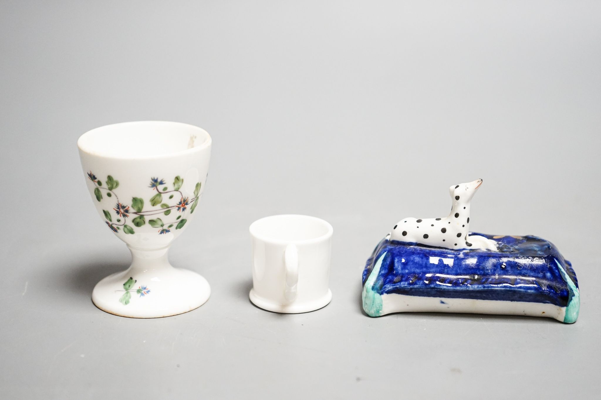 A mid 19th century Staffordshire porcelain Dalmatian pen holder and a cornflower spray egg cup and a miniature mug, tallest 6cm